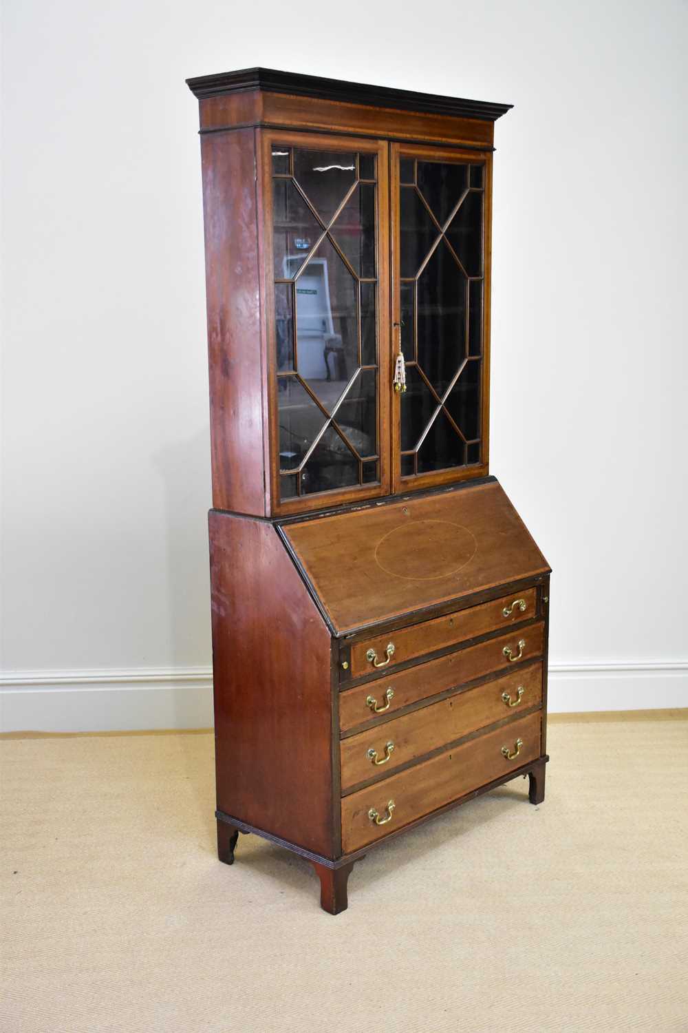 An Edwardian inlaid and crossbanded mahogany bureau bookcase with moulded cornice above a pair of