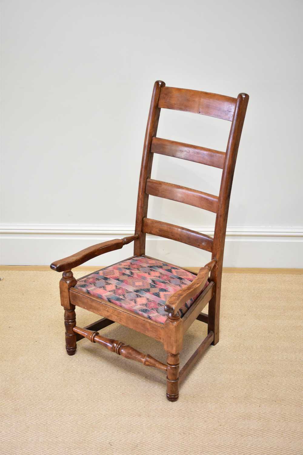 A 19th century ladderback elbow chair with drop-in seat.