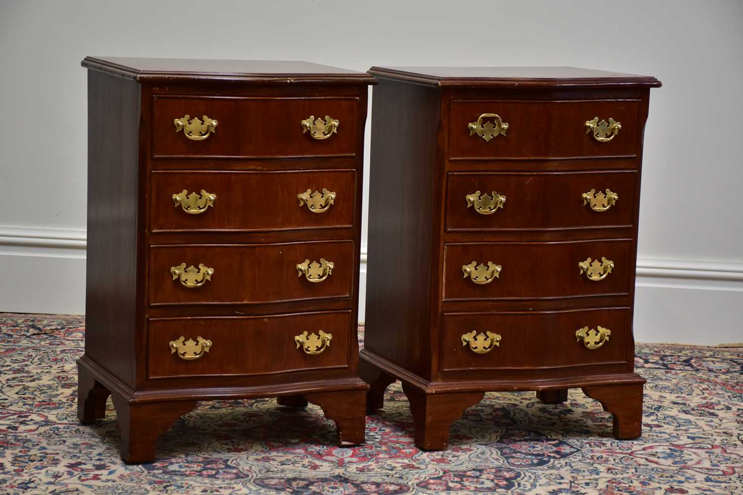 A pair of reproduction mahogany serpentine fronted chests of four drawers on bracket feet, height