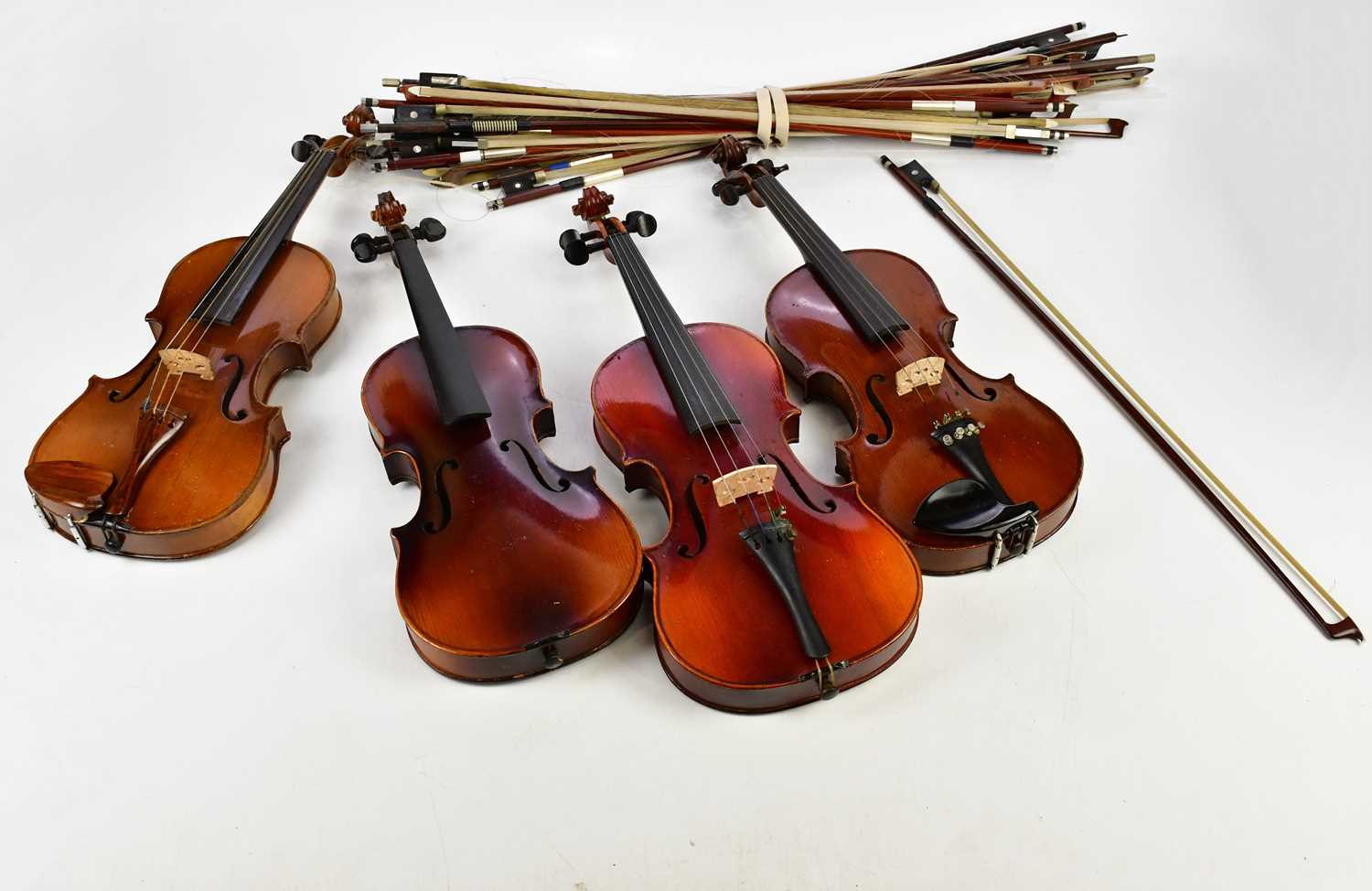 A three-quarter size violin, cased with two bows, three half size violins including one labelled for