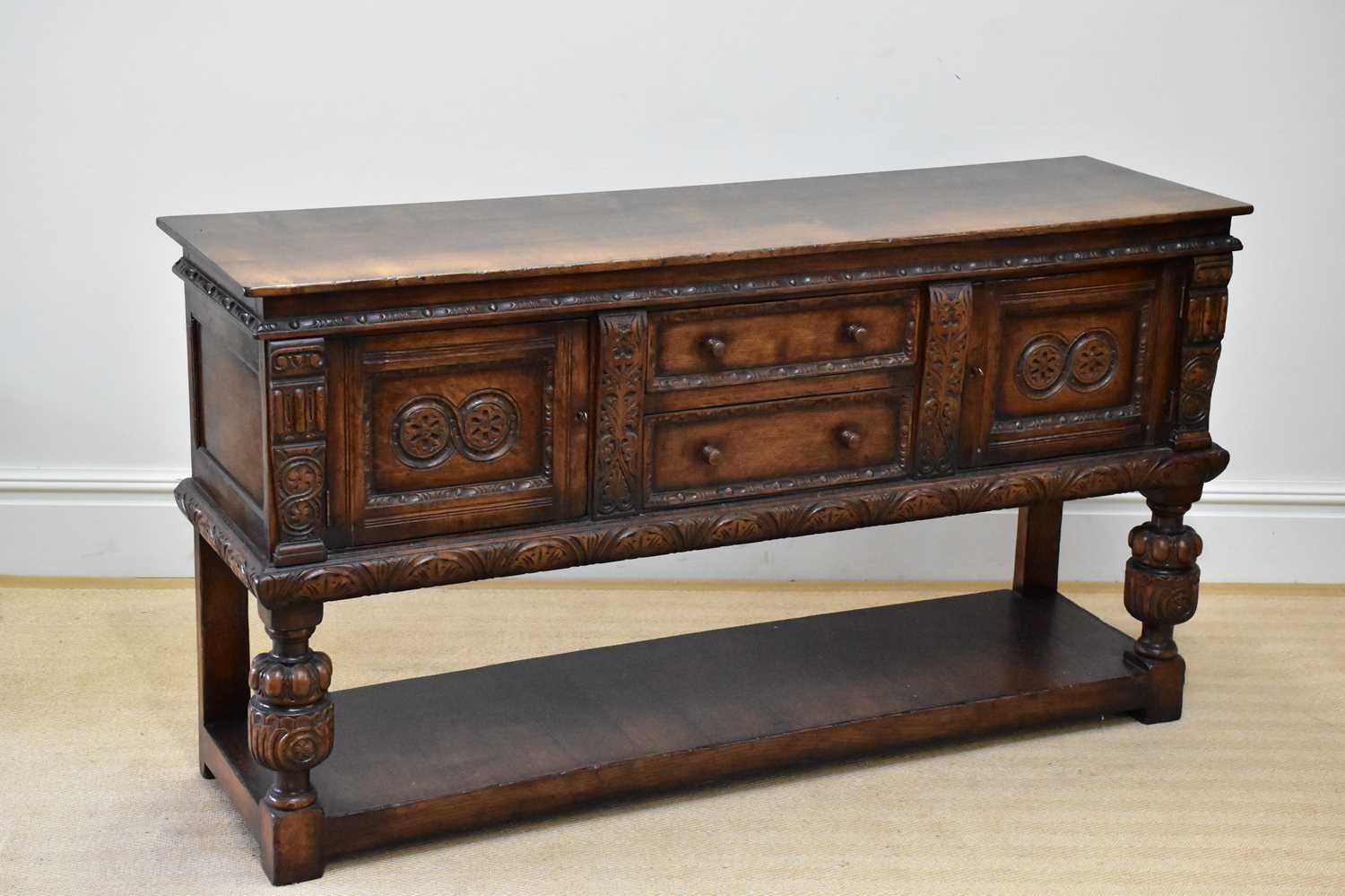 TITCHMARSH & GOODWIN; a reproduction carved oak dresser base with two drawers flanked by carved