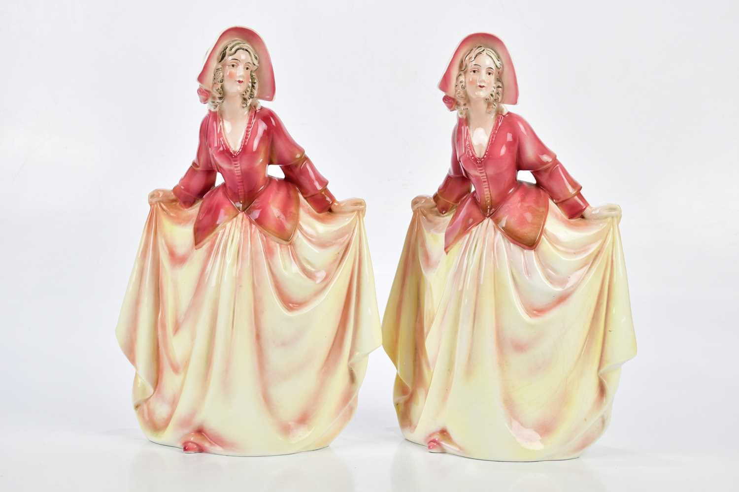 KATZHUTTE; two Art Deco ceramic figures depicting a maiden wearing a bonnet with flowing dress,