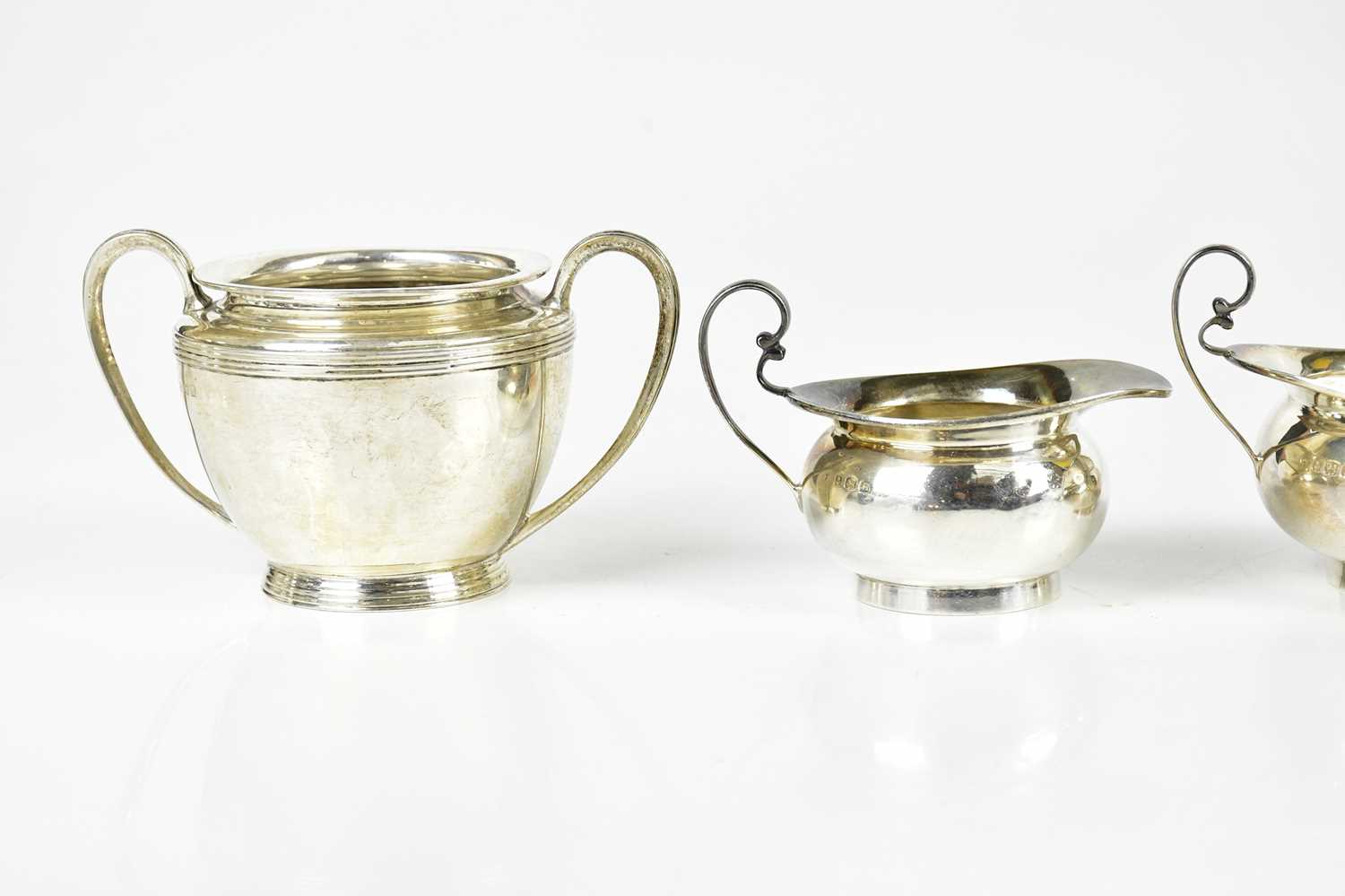 A George V hallmarked silver jug and sugar bowl, Birmingham 1919, and another jug and sugar, - Image 4 of 5