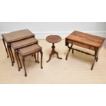 A 1950s walnut nest of three graduated coffee tables, a reproduction tripod table and a reproduction