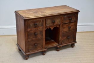 A small Victorian kneehole seven drawer sideboard, with moulded glass handles, on bun feet, width