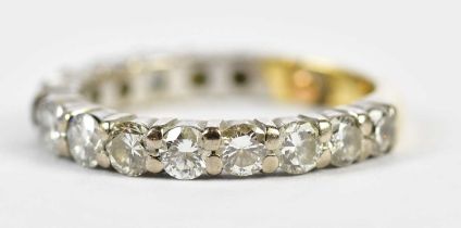 A yellow and white metal diamond three-quarter eternity ring set with fourteen round brilliant cut
