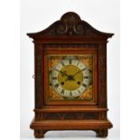 A late 19th/early 20th century German carved walnut bracket clock, the applied chapter ring set with