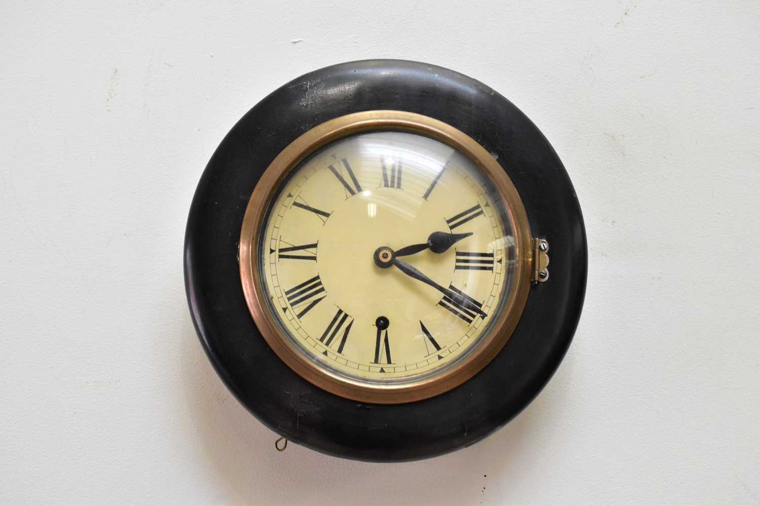 A late 19th century ebonised wall clock, the replacement papered dial set with Roman numerals,