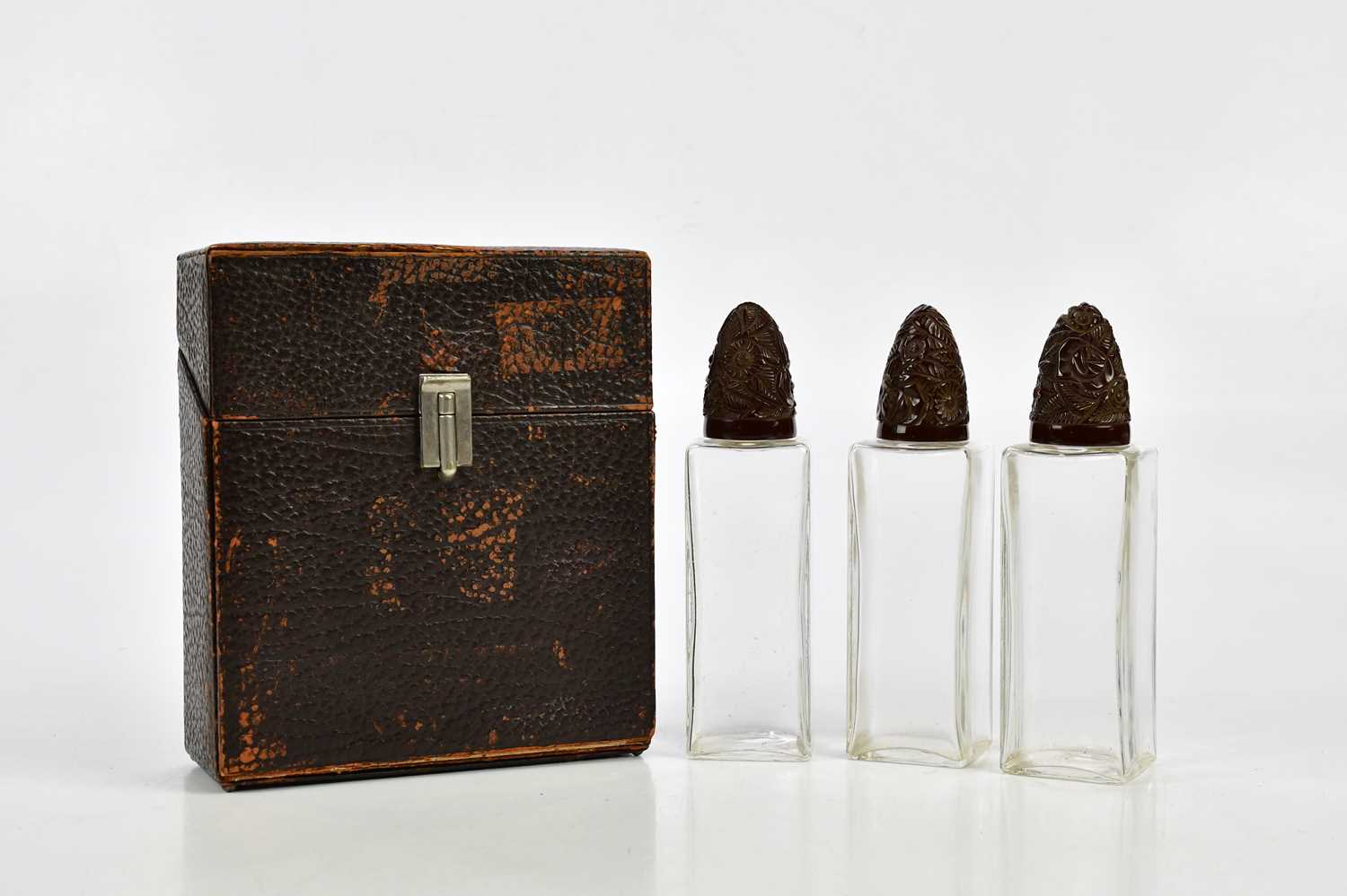 A cased set of three 1920s perfume bottles with carved resin lids, height 17cm. - Image 3 of 3
