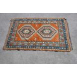 An orange ground Eastern style wool rug with geometric pattern, 210 x 140cm.