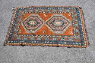 An orange ground Eastern style wool rug with geometric pattern, 210 x 140cm.