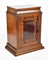 An Edwardian inlaid mahogany Sheraton Revival cabinet with single panelled door enclosing fixed