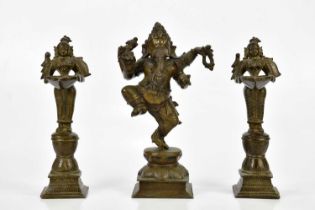 A bronze figure of Ganesh, together with a pair of bronze wick lamps, height of largest 29cm.