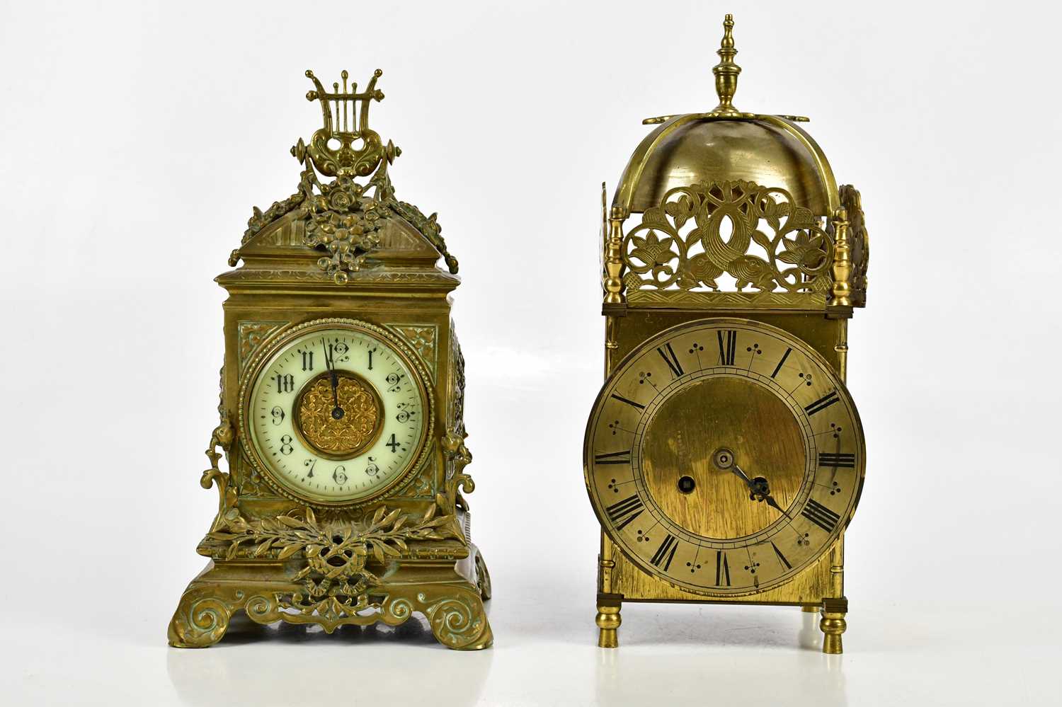 A reproduction brass lantern type mantel clock, with burnt finial above the silvered chapter ring,