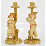 ROYAL WORCESTER; a pair of blush ivory figural candle holders, a boy and girl standing beside