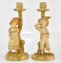 ROYAL WORCESTER; a pair of blush ivory figural candle holders, a boy and girl standing beside