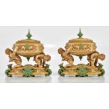 ROYAL WORCESTER; a pair of unusual lidded urn vases of oval form, the urns supported by cherubs on a