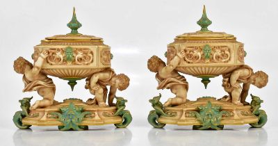 ROYAL WORCESTER; a pair of unusual lidded urn vases of oval form, the urns supported by cherubs on a