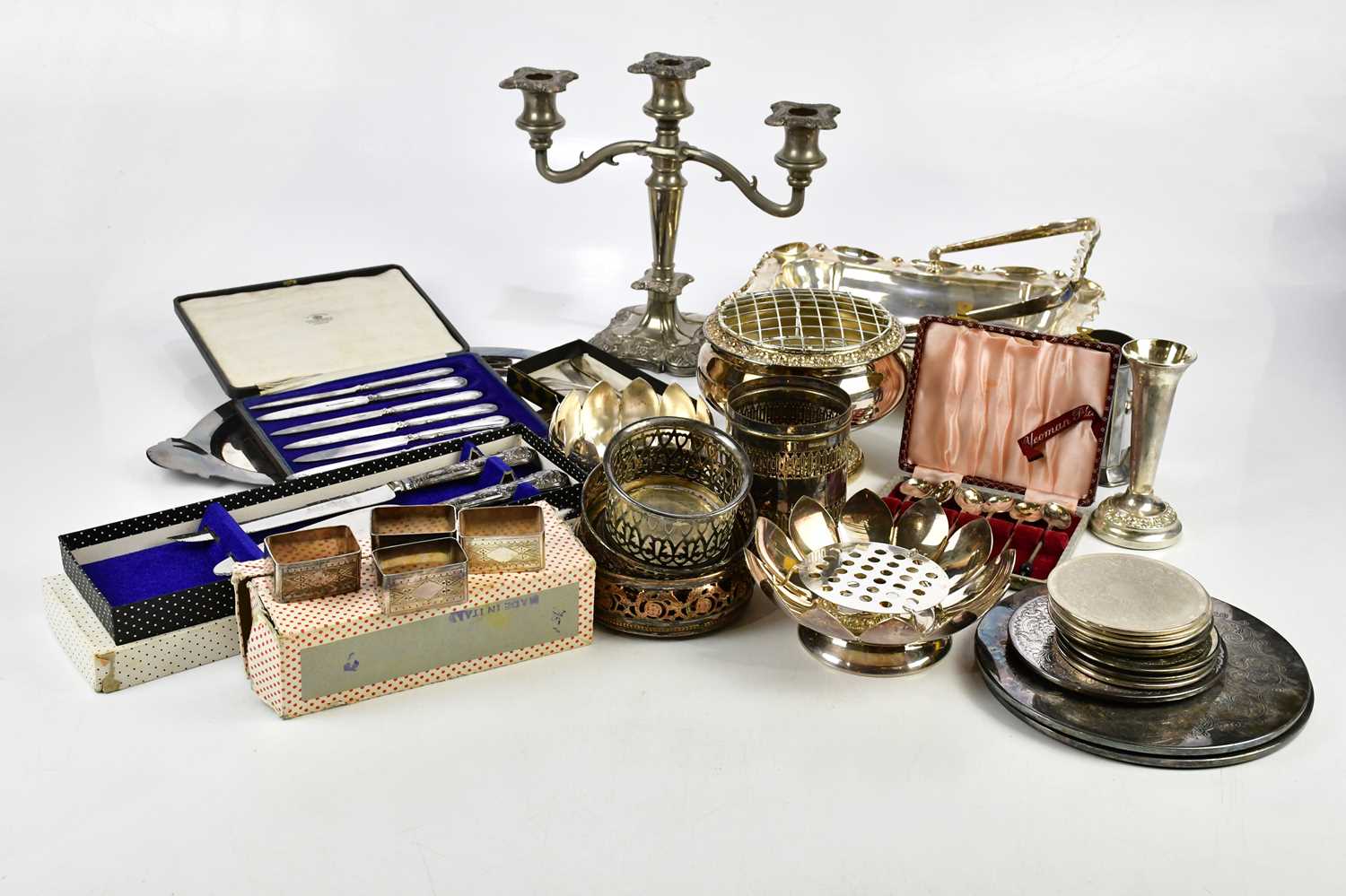 A quantity of electroplated items to include cutlery, a rose bowl, a candlestick, bottle coasters,