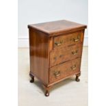 A 1950s walnut chest, with fold-over top over three drawers on pad feet, height 74cm.