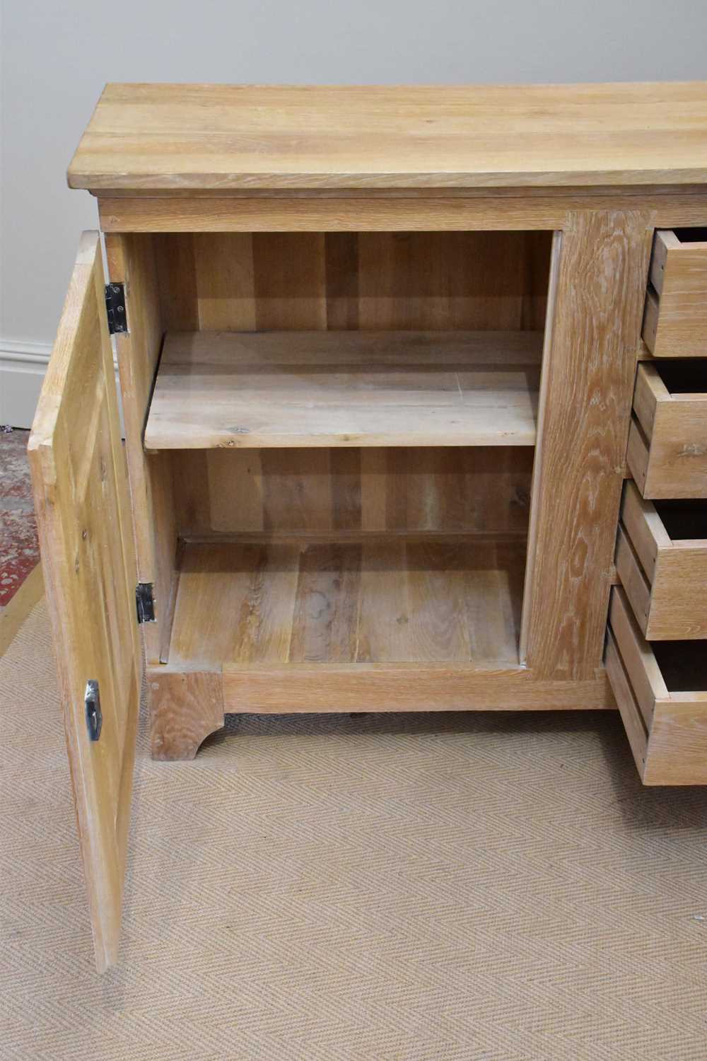 A modern limed oak sideboard with four drawers flanked by panelled cupboard doors, length 216cm, - Image 4 of 5