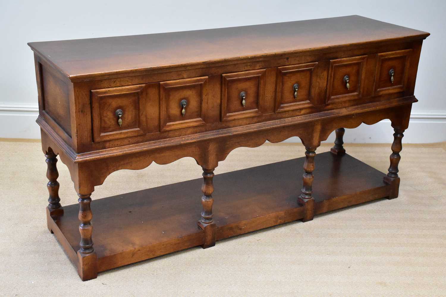 A reproduction oak dresser base with three panelled drawers and undertier, width 172cm, depth