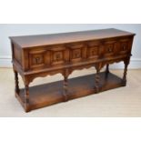 A reproduction oak dresser base with three panelled drawers and undertier, width 172cm, depth