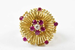 A large 18ct yellow gold floral cluster ring set with central diamond surrounded by rubies, size