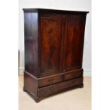 A George III mahogany linen press, with two doors above three drawers, on bracket feet, converted