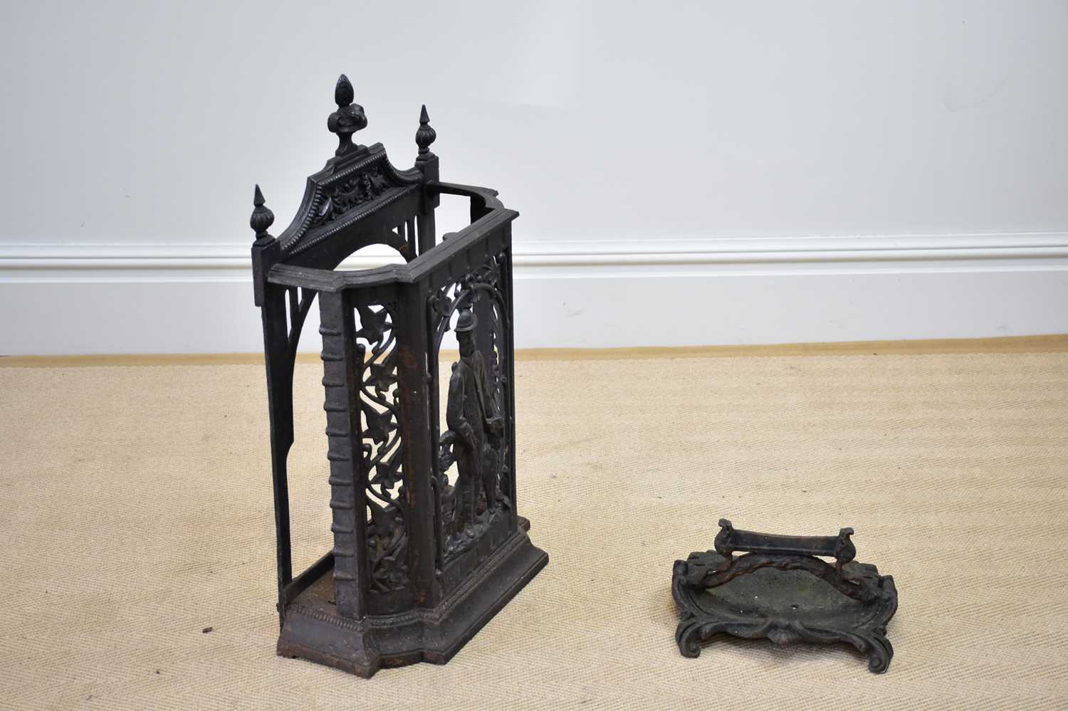 A cast iron stick stand, decorated with a sporting scene, height 78cm, and a cast iron boot