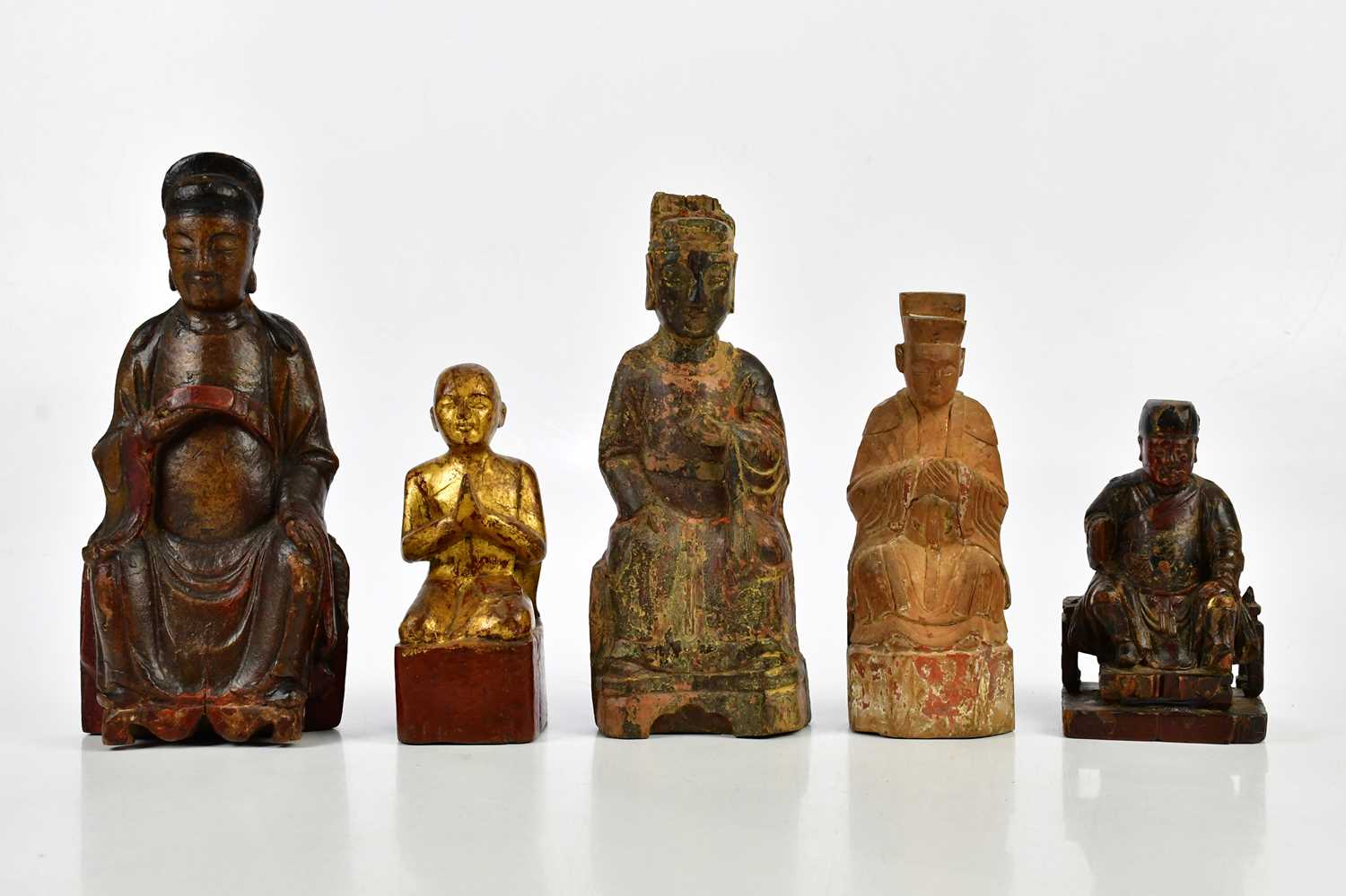 A group of five carved wooden painted Chinese figures, largest 29cm.