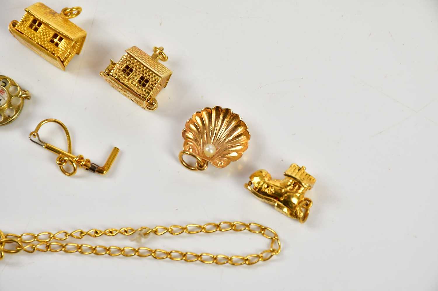 A collection of six 9ct gold charms including a riding crop, cottage, telephone dial, also a 9ct - Bild 2 aus 4