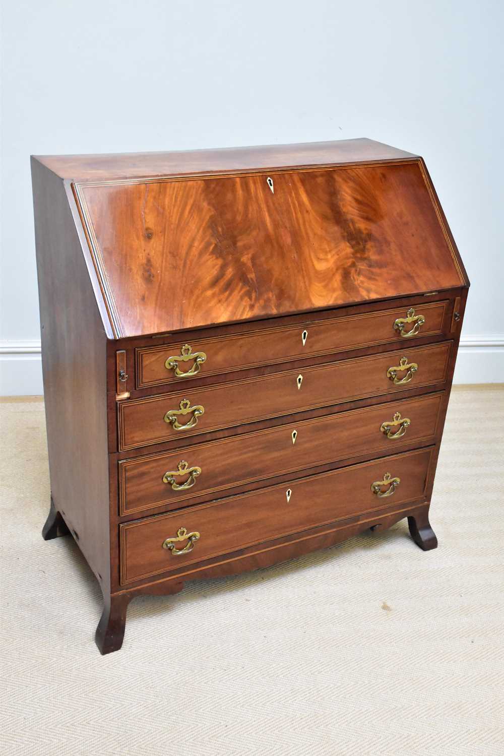 A late George III mahogany bureau, with fall front above four graduated long drawers, on splayed