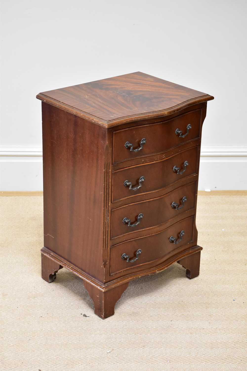 A reproduction mahogany serpentine fronted chest of four drawers, on bracket feet, height 72cm,