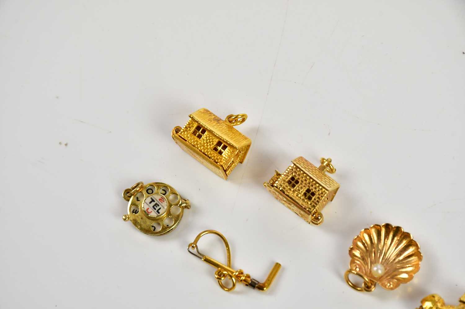 A collection of six 9ct gold charms including a riding crop, cottage, telephone dial, also a 9ct - Bild 3 aus 4