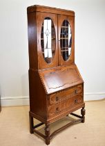 An early 20th century oak bureau bookcase, with two leaded glazed doors above fall front and two