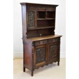 An early 20th century Flemish style dresser with plate rack back, the moulded cornice above a single