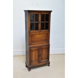 A 1920s oak bureau cabinet, with a pair of glazed doors above fall front and two panelled cupboard