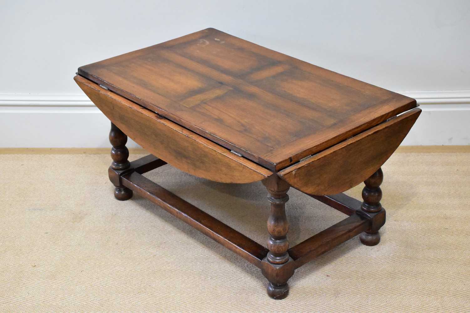 A reproduction oak drop-leaf coffee table, length 120cm, height 50cm.