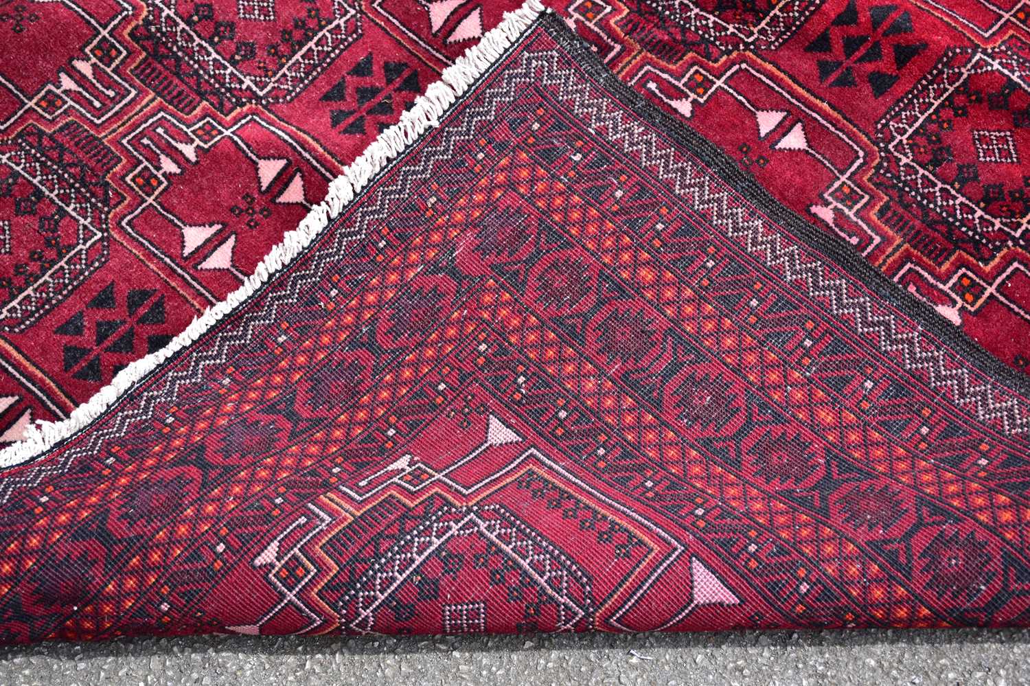 A red ground rug in the Bokhara style with stylised decoration and a further red and ivory ground - Image 4 of 4
