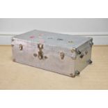 A silvered metal trunk with studded detail and applied vintage labels including 'Munson Steamship