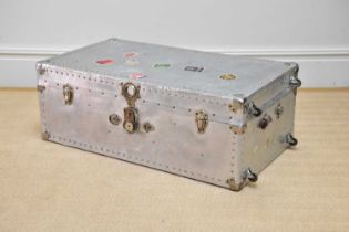 A silvered metal trunk with studded detail and applied vintage labels including 'Munson Steamship