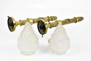 A pair of brass wall lights modelled as torches, with moulded frosted glass 'flame' shades, height