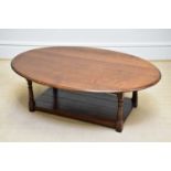 A reproduction oak oval topped coffee table with undertier, on block legs, length 120cm, height