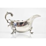 WILLIAM AITKEN; a late Victorian hallmarked silver sauce boat on three pad feet with C-scrolling