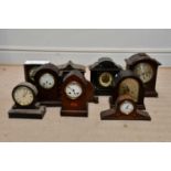 An Edwardian inlaid oak lancet shaped mantel clock, with a selection of further wooden and slate