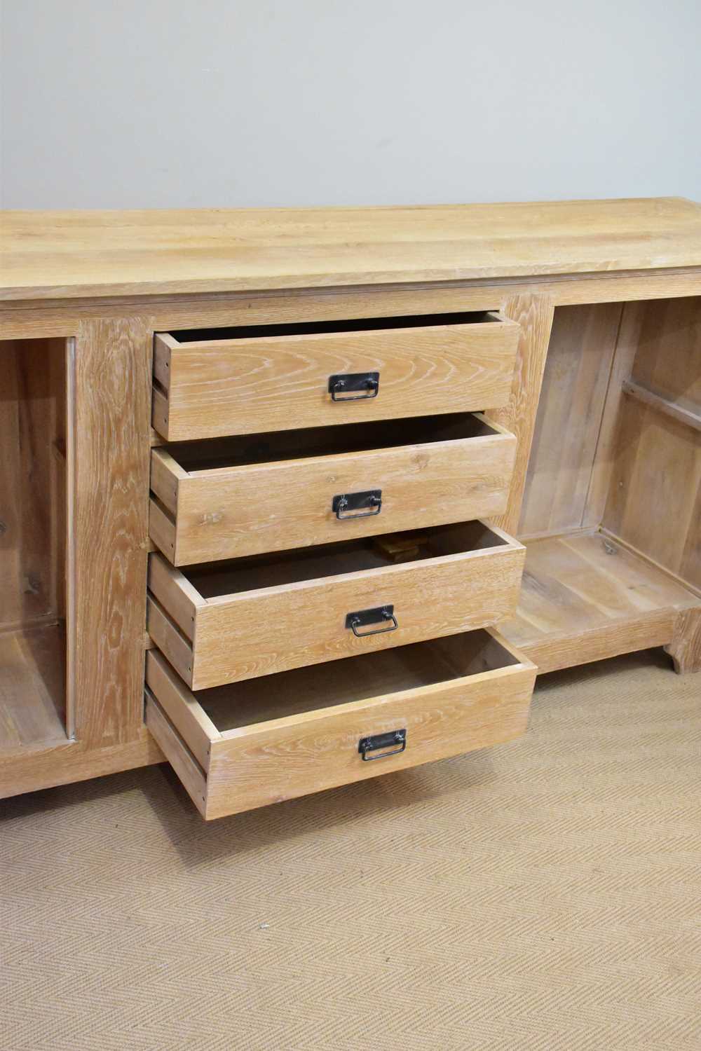 A modern limed oak sideboard with four drawers flanked by panelled cupboard doors, length 216cm, - Image 3 of 5