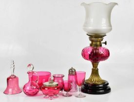 A small collection of cranberry glass items including a bowl, a sugar caster, a trinket box with