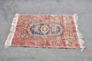 An orange ground silk carpet with central geometric pattern, 160 x 109cm.