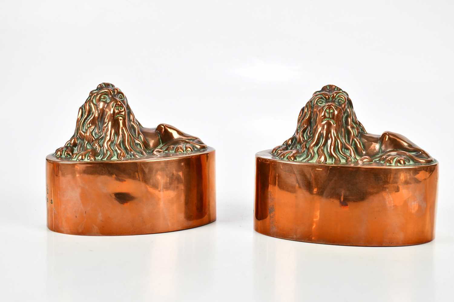 BENHAM & FROUD; a pair of 19th century copper jelly moulds of oval form, topped with recumbent